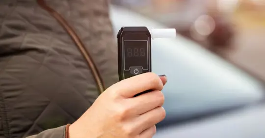 driver holding a breathalyzer